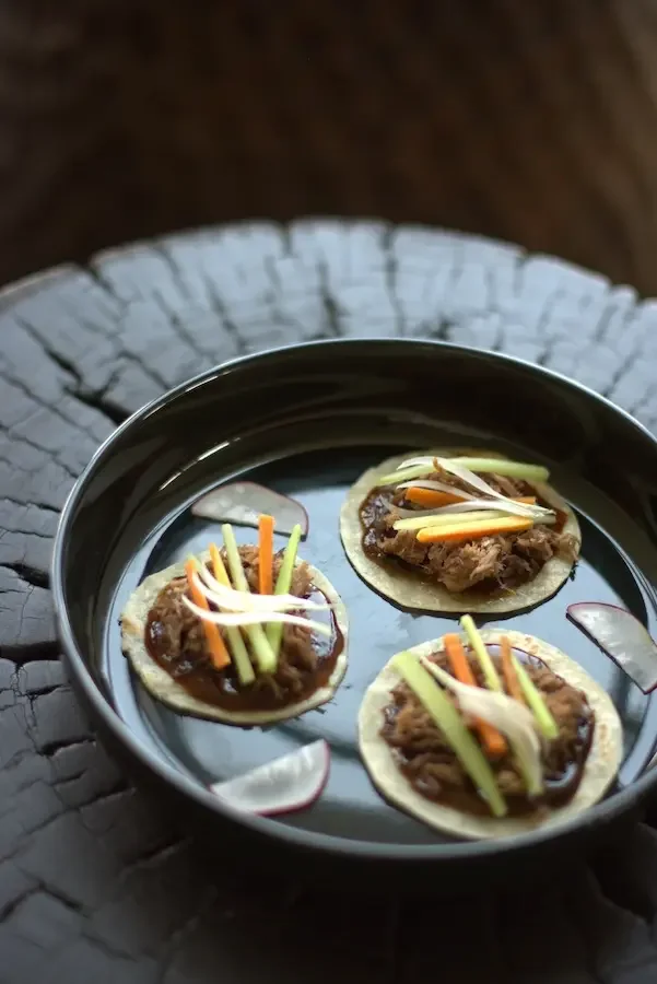 Receta servida con pato y elementos de acompañamiento